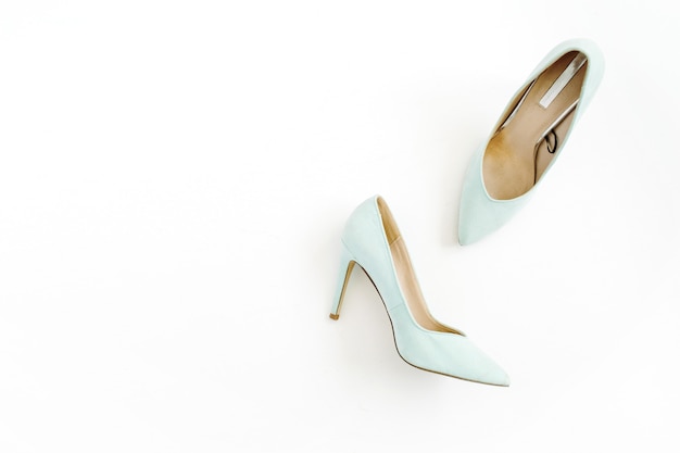 Beauty blog concept. Pale blue female shoes on white.