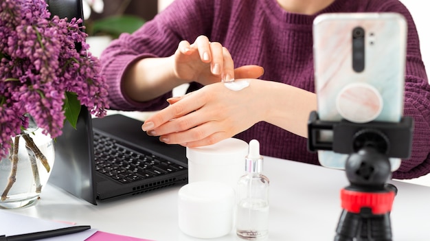 Beauty blogger apply cream on female hands