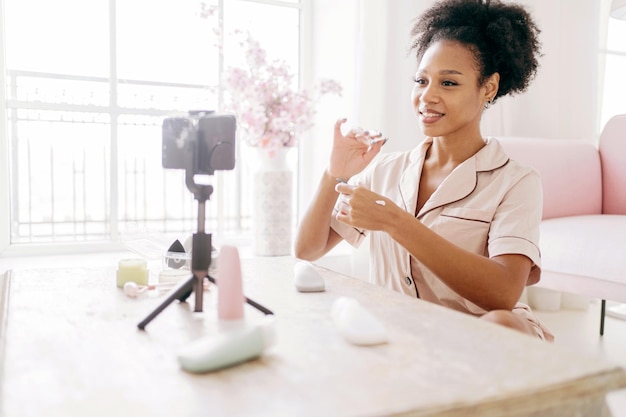 Photo beauty blogger smiling demonstrating skincare products on camera