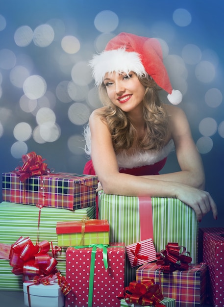 Beauty blonde girl in santa hat on gray background