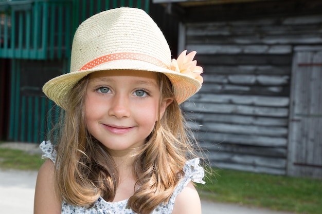 Beauty blue eyes and straw hat child girl in spring summer outdoors day