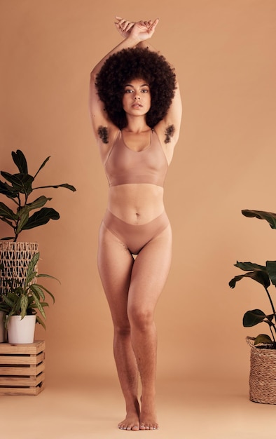 黒人女性のプライドとエンパワーメント化粧品とヘアケアの肖像画を持つ自然な体と脇毛の美しさ アフリカ モデルの下着とスタジオの背景を持つアフロの自信と健康