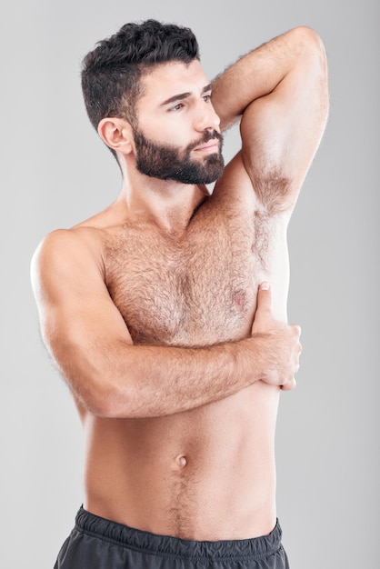 Foto bellezza corpo e ascelle con un modello uomo in studio su uno sfondo grigio per la salute o il benessere petto e muscoli della pelle con un bel giovane maschio in piedi al coperto per promuovere uno stile di vita salutare