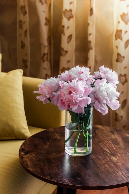 Beauty bouquet of pink peonies on a wooden table in a cozy room Home still life interior concept
