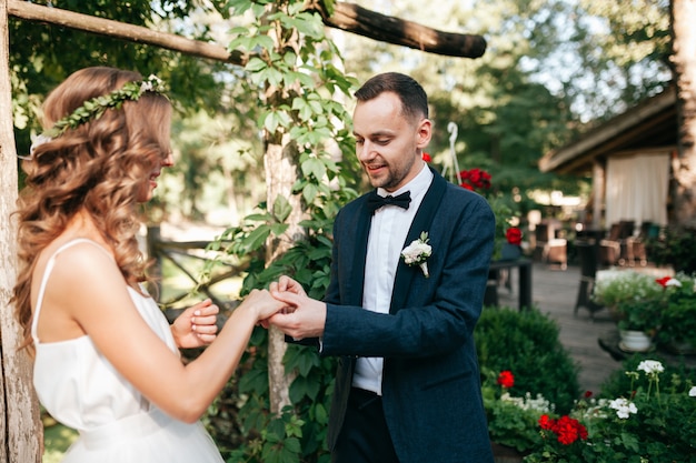 Beauty bride and handsome groom are wearing rings each other.