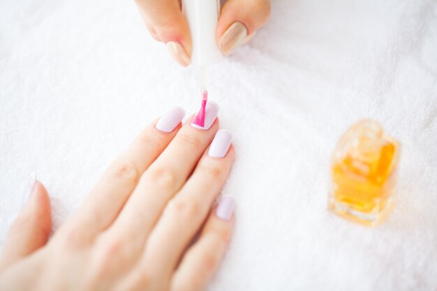 Beauty and Care. Manicure Master Applying Nail Polish in Beauty Salon. Beautiful Women's Hands with Perfect Manicure. Spa Manicure