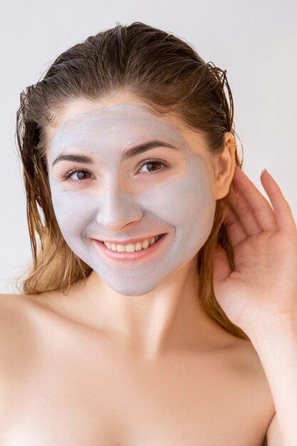 Beauty care skin treatment woman clay mask on face