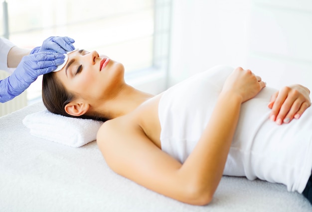 Beauty and Care. Young Girl with Clean Skin in Spa Salon. Woman Relaxing And Lying With Closed Eyes. High Resolution