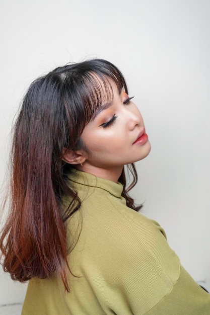 Красивое веселое лицо азиатской молодой модели в зеленом топе Уход за кожей лица уход за лицом спа концепция женского здоровья