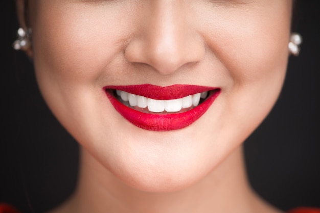 Beauty. Close up view of beautiful woman lips with red matt lipstick