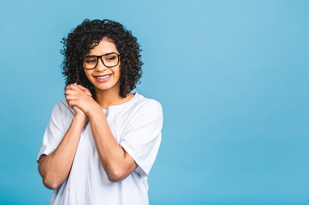 Beauty closeup portrait of young african american girl with afro hair. Isolated over blue background.