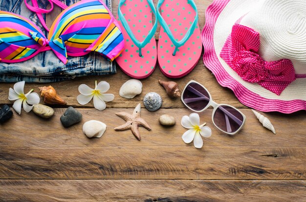 Beauty colorful bikini and accessories on wooden floor