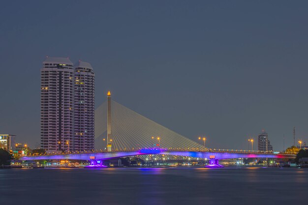 The beauty of colorful lights on Pinklao bridge and cars driving at Night on Chao Phraya River