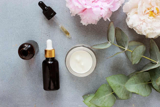 Beauty concept serum and jar with cream and eucalyptus