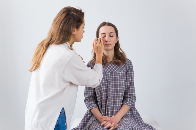 Beauty and cosmetics concept - Makeup artist doing professional make up of young woman