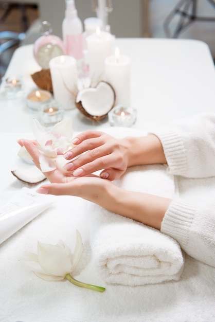 Beauty delicate hands with manicure holding flower lily.