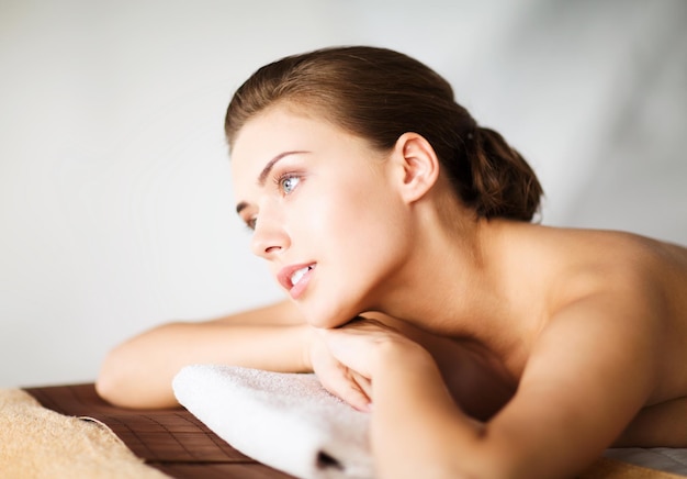 beauty en spa concept - vrouw in spa salon liggend op de massage desk