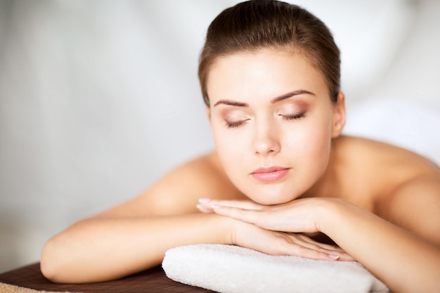 beauty en spa concept - vrouw in spa salon liggend op de massage desk