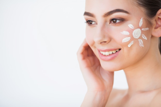 Beauty Face Care. Woman Applying Cream On Skin