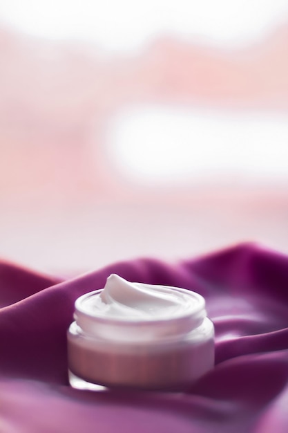 Косметический крем для лица, увлажняющий крем для чувствительной кожи, роскошная спа-косметика и натуральный чистый продукт по уходу за кожей на фиолетовой шелковой ткани