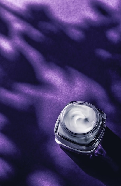 紫の背景に高級スパ化粧品と自然な顔色のスキンケア製品を保湿する敏感肌用の美容フェイスクリーム