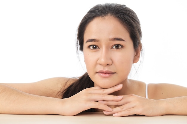 Beauty face skincare woman sitting portrait of beautiful attractive Thai Asian female model isolated on white surface.