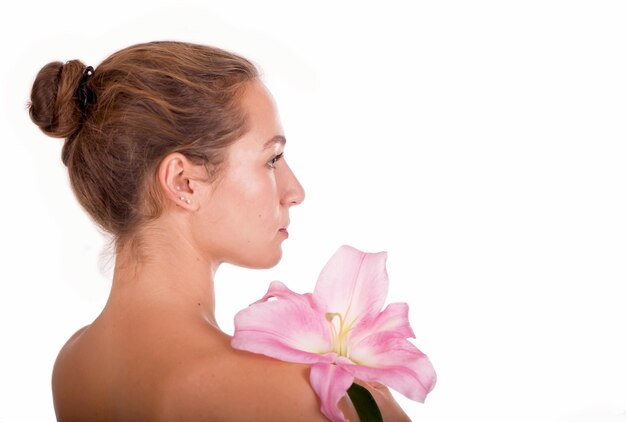 Fronte di bellezza della giovane bella donna con fiore pelle commovente femminile