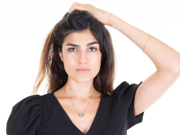 Foto bellezza viso giovane donna graziosa bruna capelli lunghi castani ritratto mano sui capelli su sfondo bianco