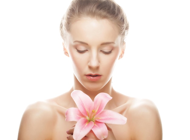 Beauty face of the young woman with pink lily