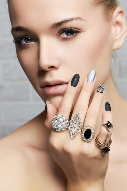 Beauty facewoman's hands with jewelry rings