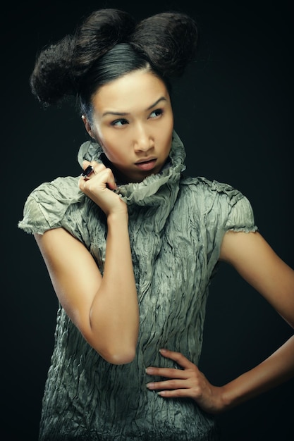 검은 배경에 회색 드레스에 아름다움과 패션 개념 젊은 아시아 패션 모델