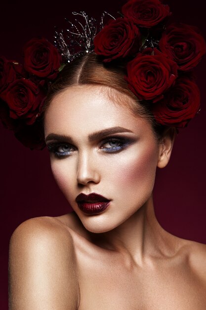 Beauty fashion model girl with dark makeup and roses in her hair