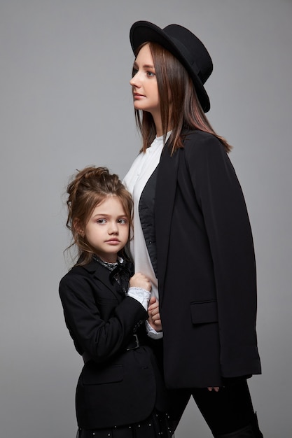 Beauty fashion mom and daughter. Family photo shoot, joy and fun emotions. Woman and a girl Embrace