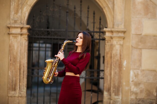 Beauty and fashion, music. Pretty woman with saxophone.