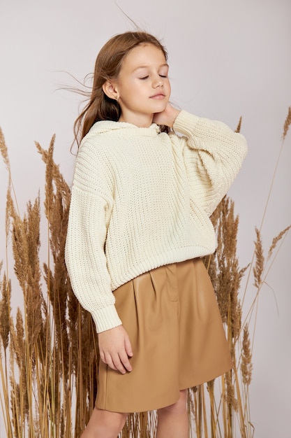 Beauty fashion portrait girl in grass in spring on a white background. Smile on girl face