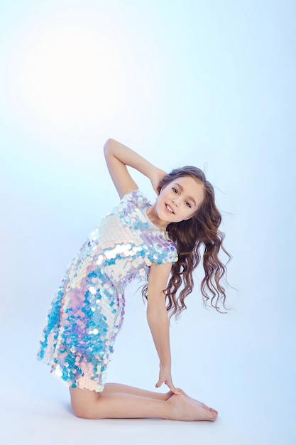 Beauty fashion portrait of a young girl in a dress on a light background