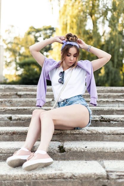 Beauty fashion woman with bandana and fashionable casual clothes sitting on the steps