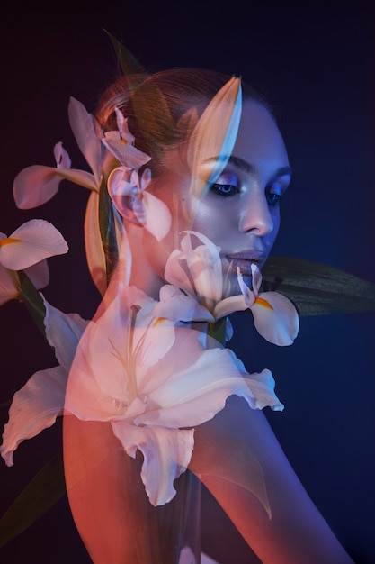 Beauty flowers face of a woman with double exposure. Portrait of a girl neon light and color, professional makeup, nude back of a woman, flowers in the head