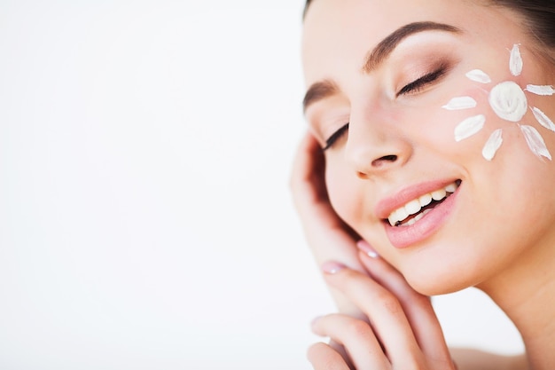 Beauty Girl Applying Sun Tan Cream on her Face