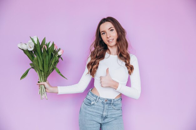 Beauty girl holding Spring tulips Flower bouquet and smiling. Valentine's Day. Mother's Day.