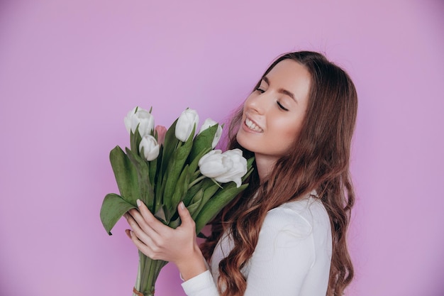 春のチューリップの花の花束を持って笑顔の美女。バレンタイン・デー。母の日。