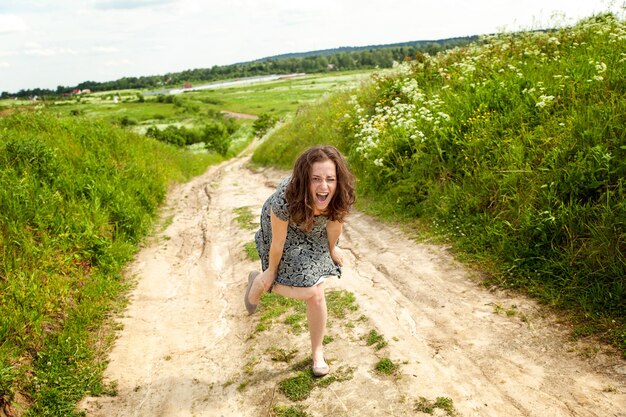 Beauty girl outdoors enjoying nature. beautiful young woman jumping on summer field