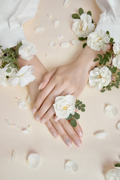 Beauty hands woman with rose flowers are on the table