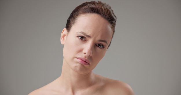 beauty health cosmetics antiaging therapy and skin care concept young beautiful brunette caucasian woman in a bad mood upset and disappointed experiencing negative emotions