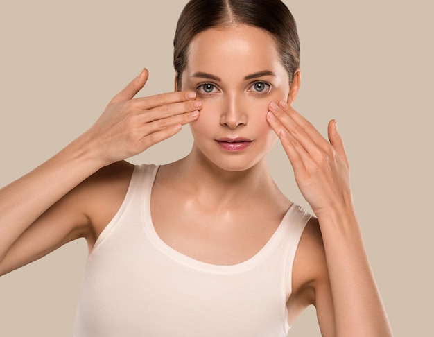 Beauty healthy skin woman touching her face. Beautiful female. Color background. Brown