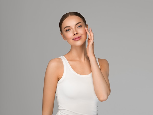 Beauty healthy skin women touching face cosmetic studio portrait. Sportswear color background gray