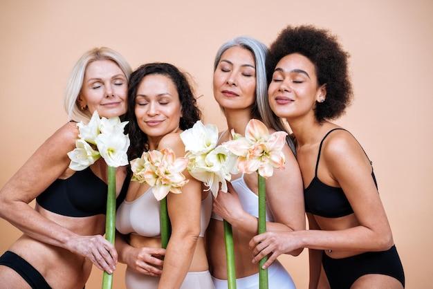 Beauty image of a group of women with different age, skin and body posing in studio for a body positive photoshooting. Mixed female models in lingerie on colored backgrounds