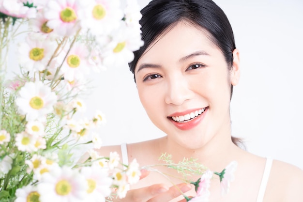 写真 花を持つ若いアジアの女性の美しさの画像