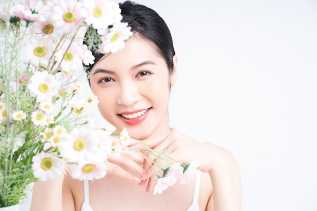 写真 花を持つ若いアジアの女性の美しさの画像