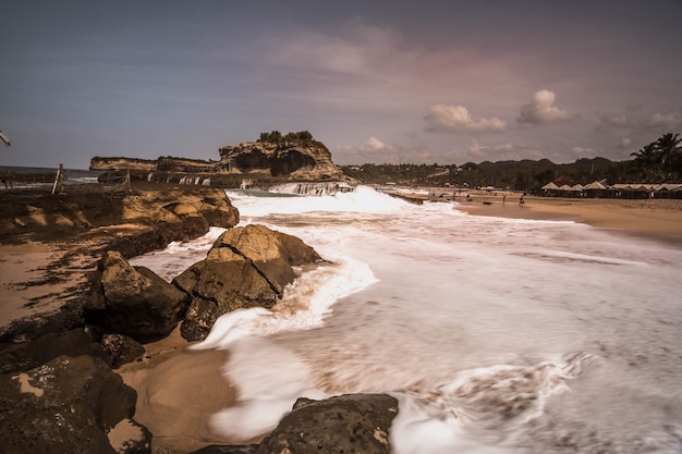 Foto la bellezza della spiaggia di klayar pacitan con barriere coralline e sabbia bianca, onde alte sulla costa sud dell'isola di giava, indonesia